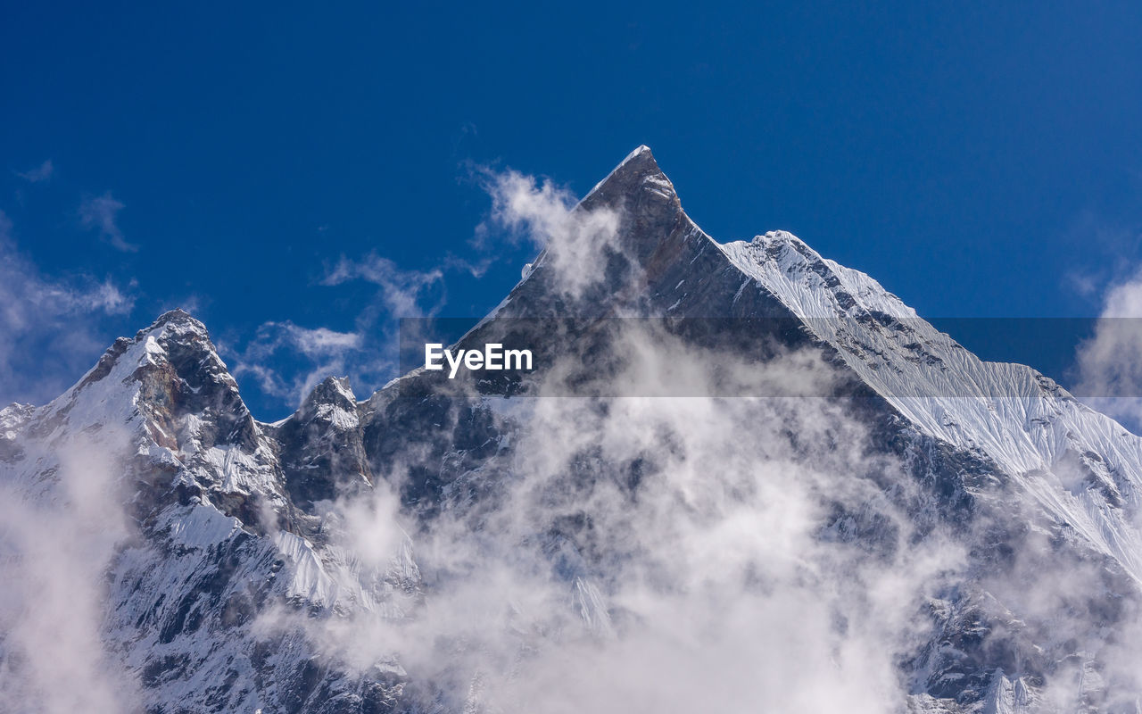 Low angle view of snowcapped mountain against sky