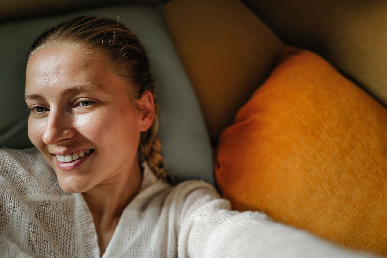 Woman relaxing on the colorful pillows smiling