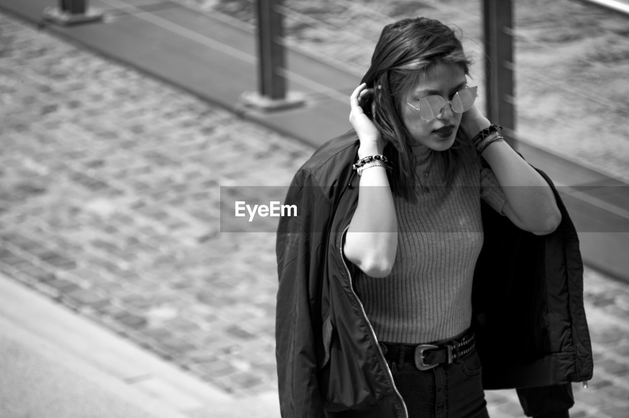 High angle view of woman in sunglasses walking on street