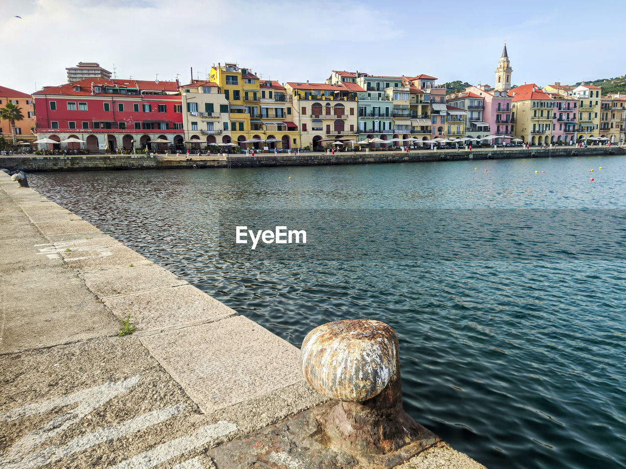 Imperia harbor with colorful buildings along the waterfront, clear sky, and calm 