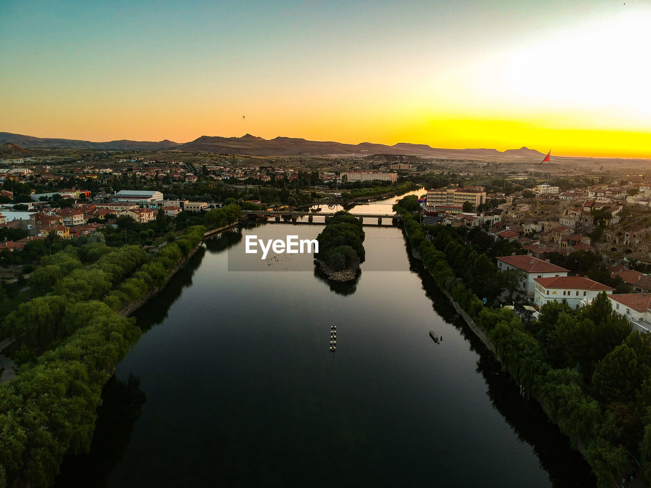 HIGH ANGLE VIEW OF RIVER AMIDST BUILDINGS AGAINST SKY