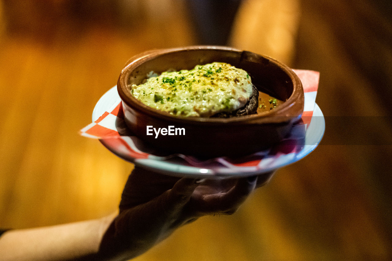 Close-up of person holding ice cream in bowl