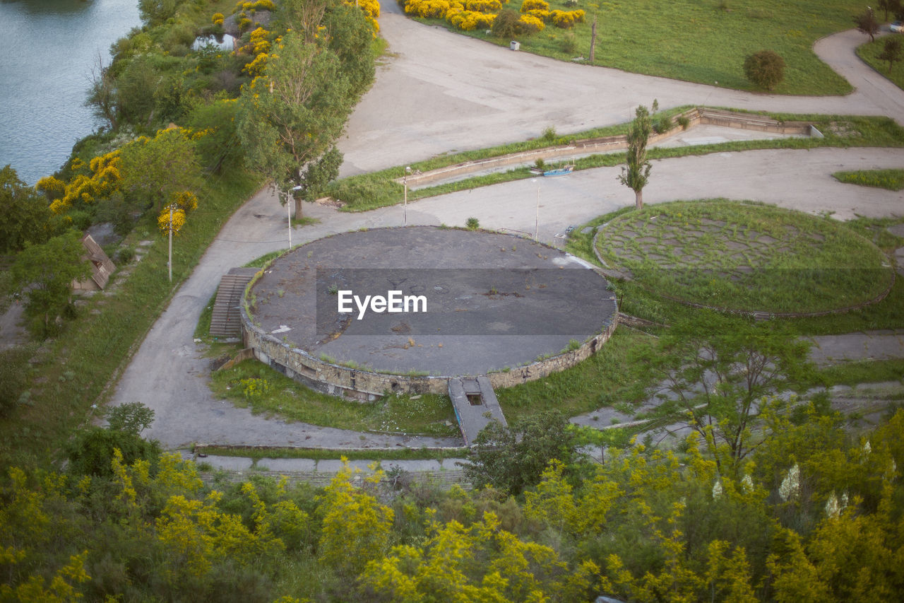 HIGH ANGLE VIEW OF ROAD AMIDST TREES AND PLANTS