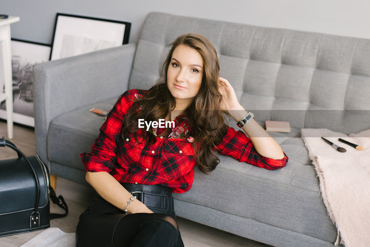 Young beautiful european makeup artist records a review of a cosmetic product, sitting among makeup