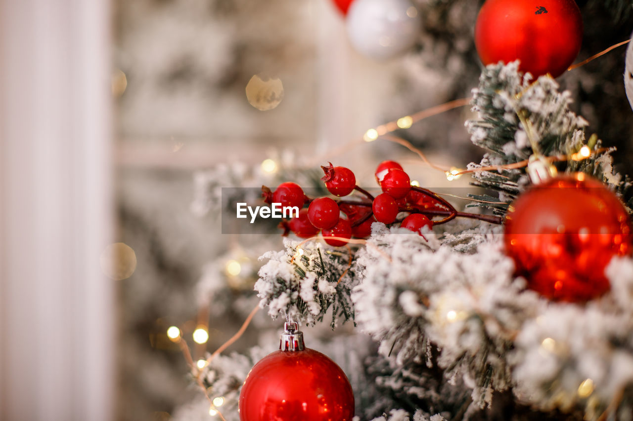 CLOSE-UP OF CHRISTMAS TREE WITH RED BERRIES ON TABLE