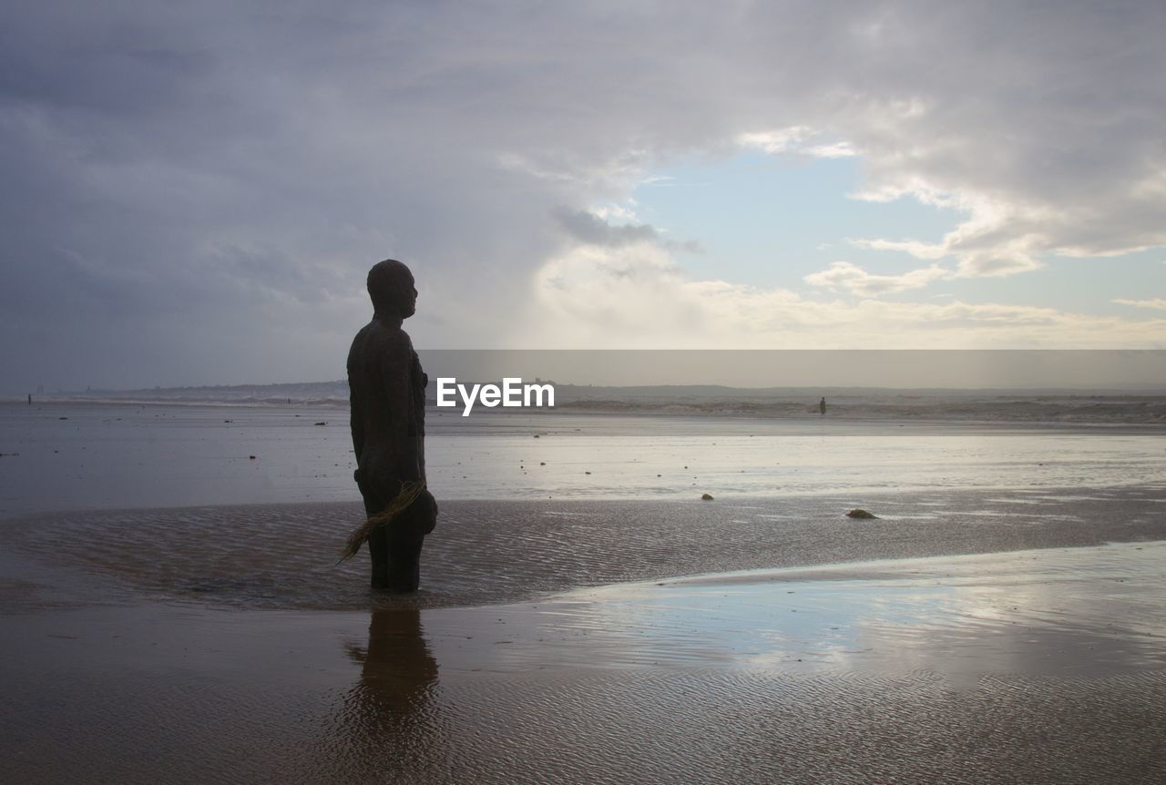 FULL LENGTH OF MAN STANDING ON BEACH