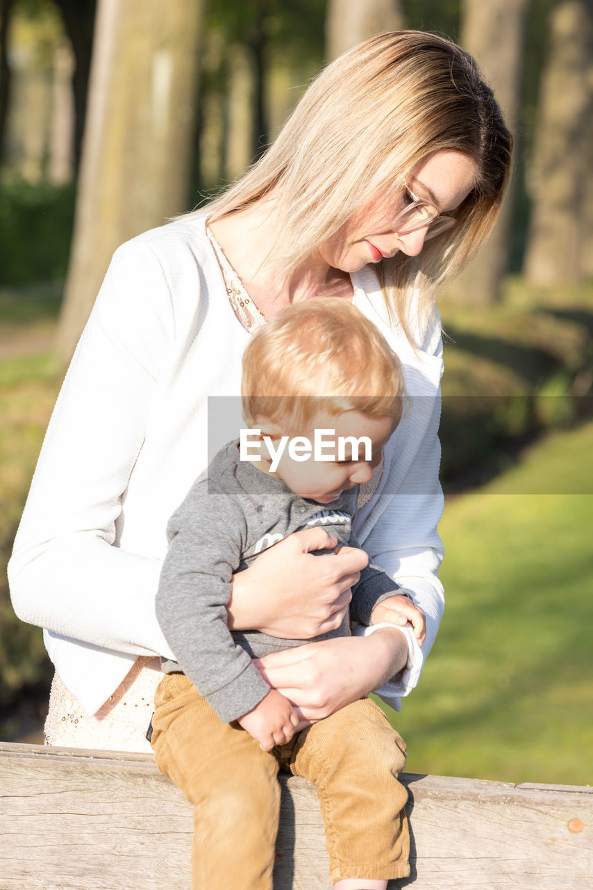 high angle view of mother and daughter sitting at park