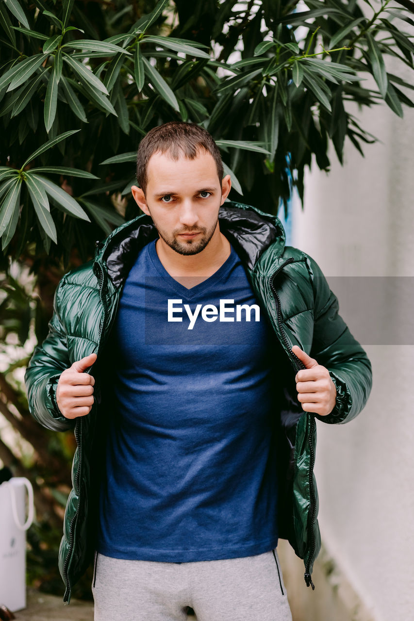 Portrait of man wearing jacket standing outdoors