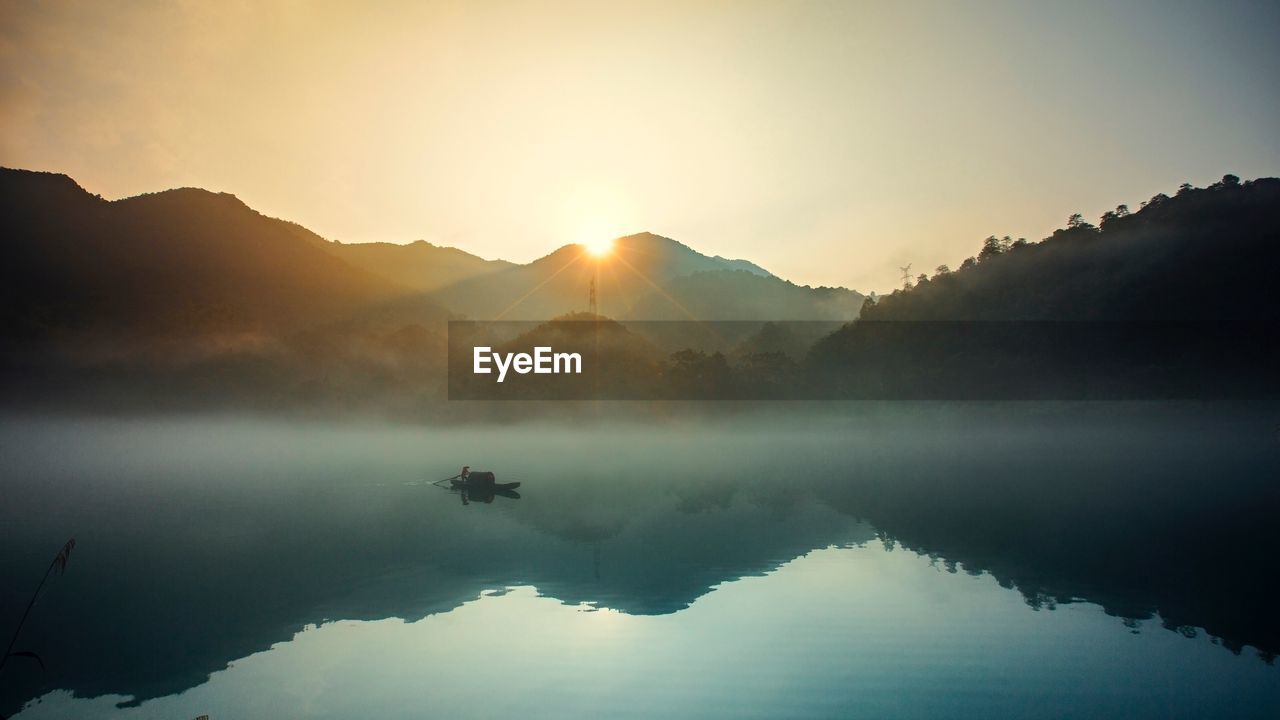 Scenic view of lake and mountains against clear sky