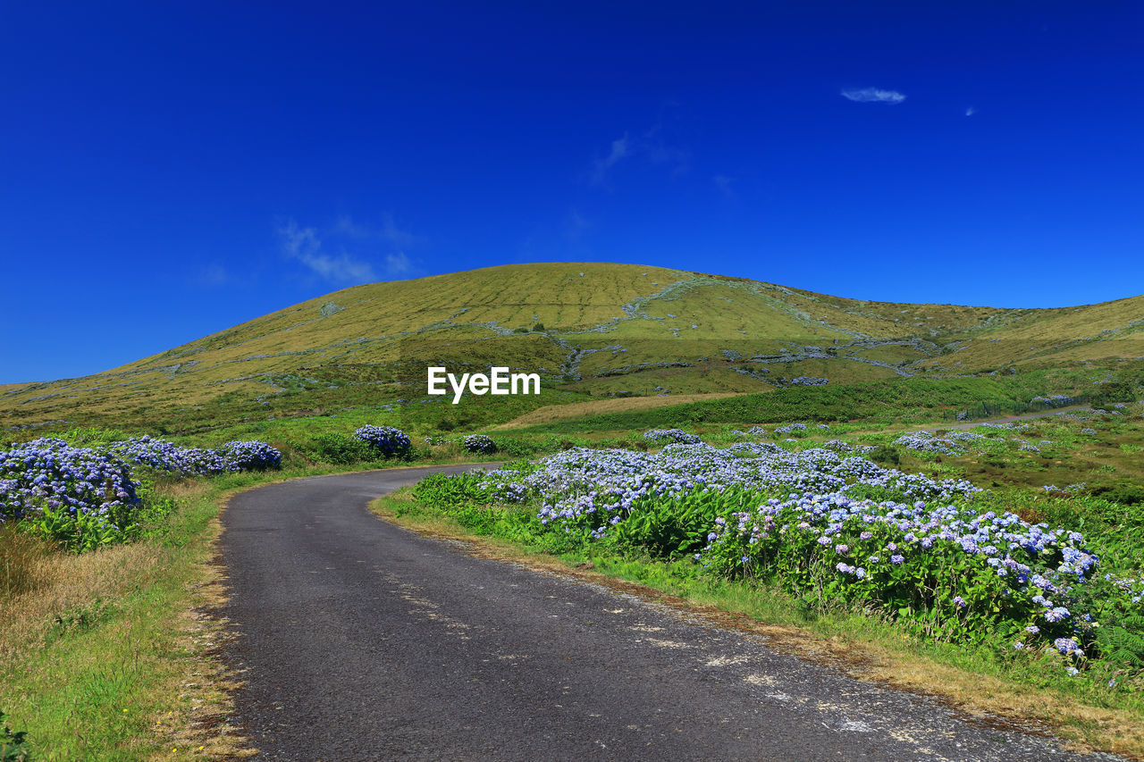 Scenic view of mountain road against blue sky