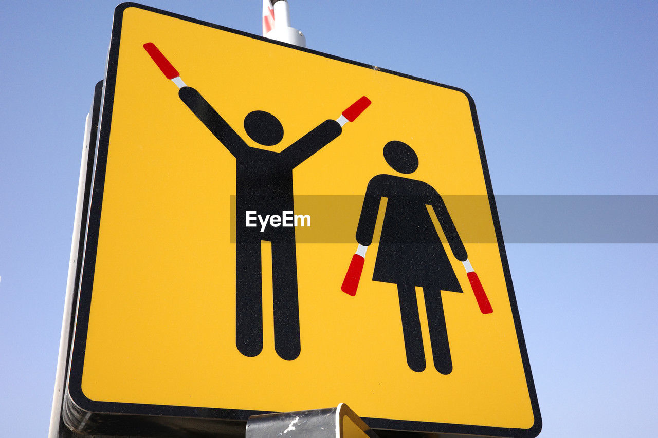 sign, communication, traffic sign, road sign, road, yellow, guidance, human representation, symbol, representation, warning sign, transportation, signage, blue, no people, font, sky, number, information sign, clear sky, male likeness, nature, street sign