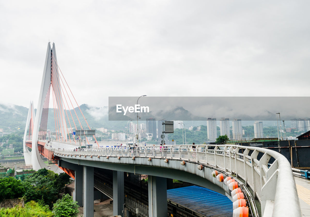 Bridge over cityscape against sky