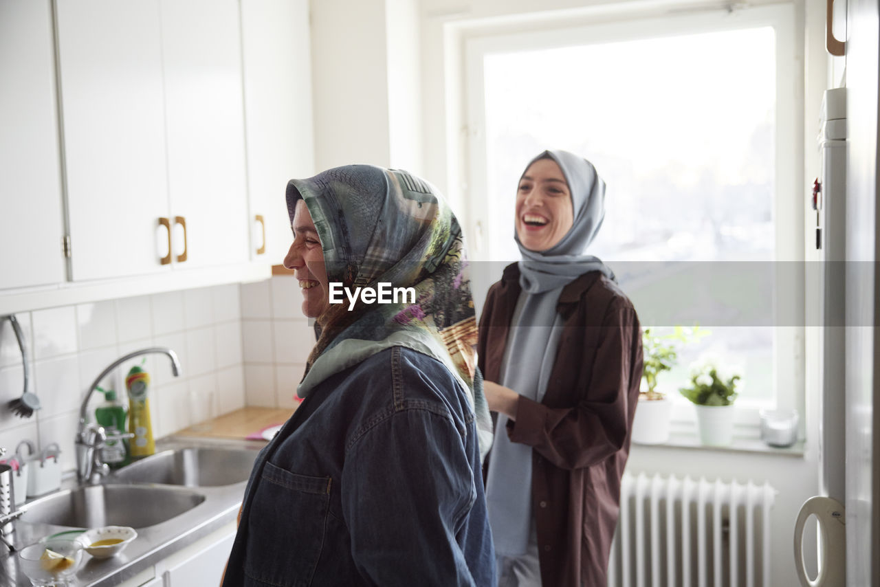 Women in headscarves cooking together for eid al-fitr at home