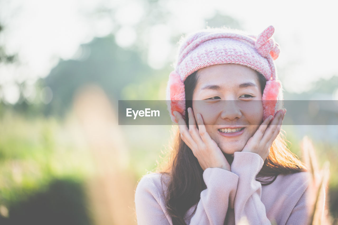 Close-up of smiling woman wearing ear muff