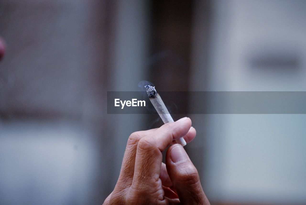 Cropped image of person smoking