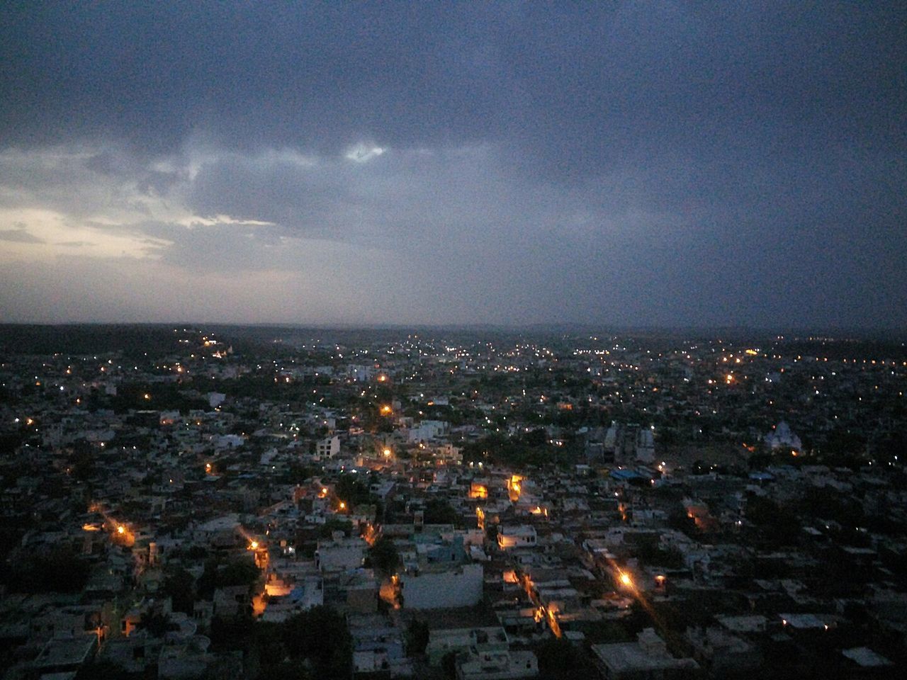 AERIAL VIEW OF ILLUMINATED CITYSCAPE AT NIGHT