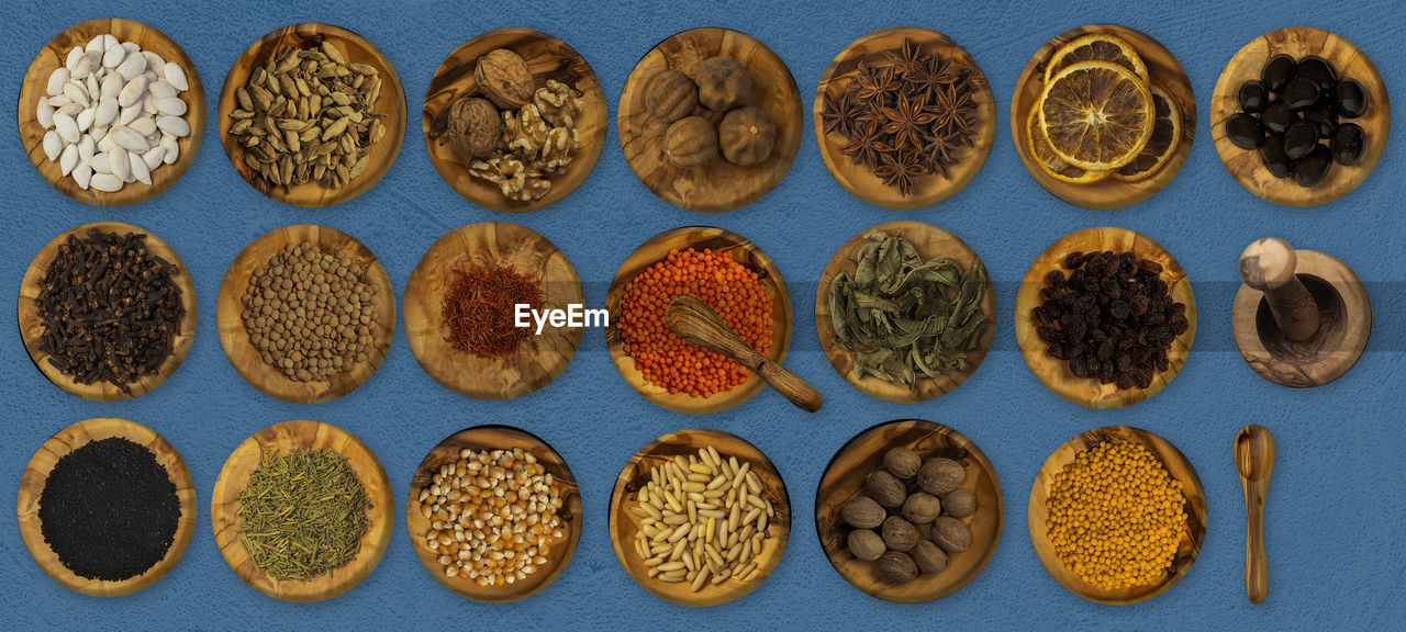 Top view of spices and food ingredients in wooden small plates .