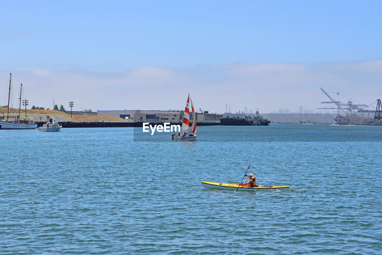 BOAT SAILING IN SEA AGAINST SKY