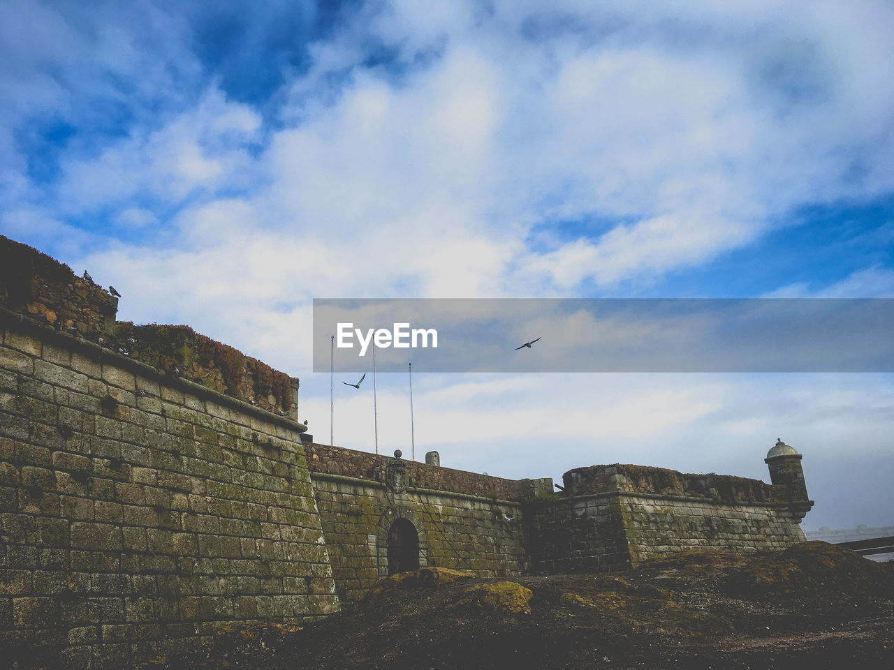 LOW ANGLE VIEW OF HISTORICAL BUILDING AGAINST CLOUDY SKY