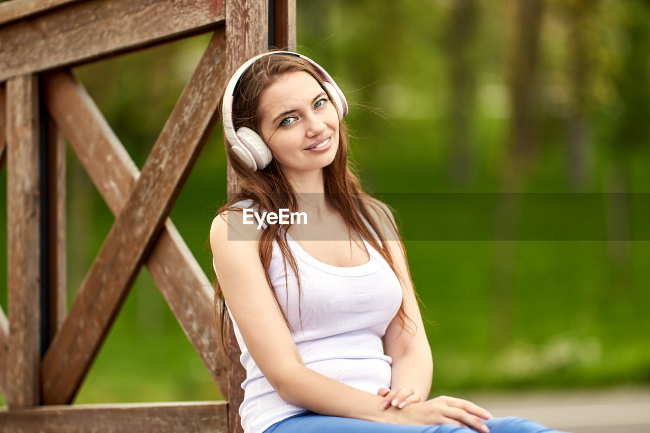 Portrait of smiling young woman sitting on bench