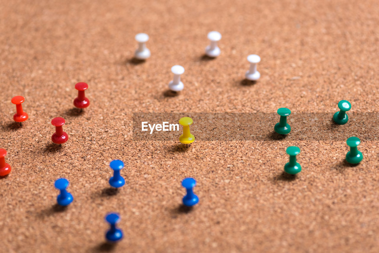 High angle view of multi colored thumbtacks on table