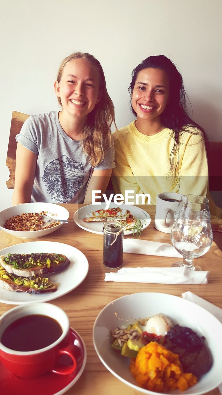 Portrait of smiling young woman sitting at table