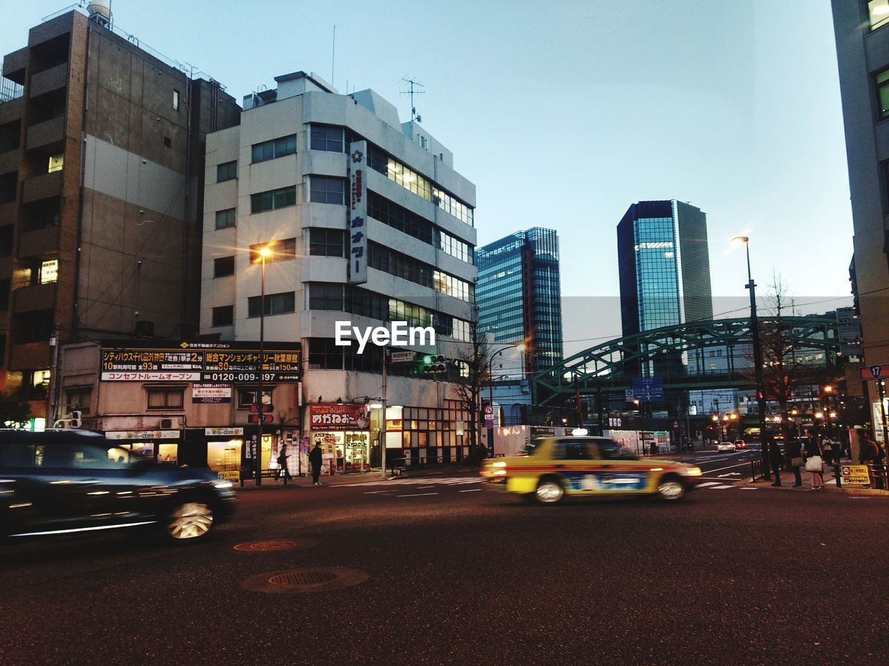 CARS ON ROAD AGAINST SKY IN CITY