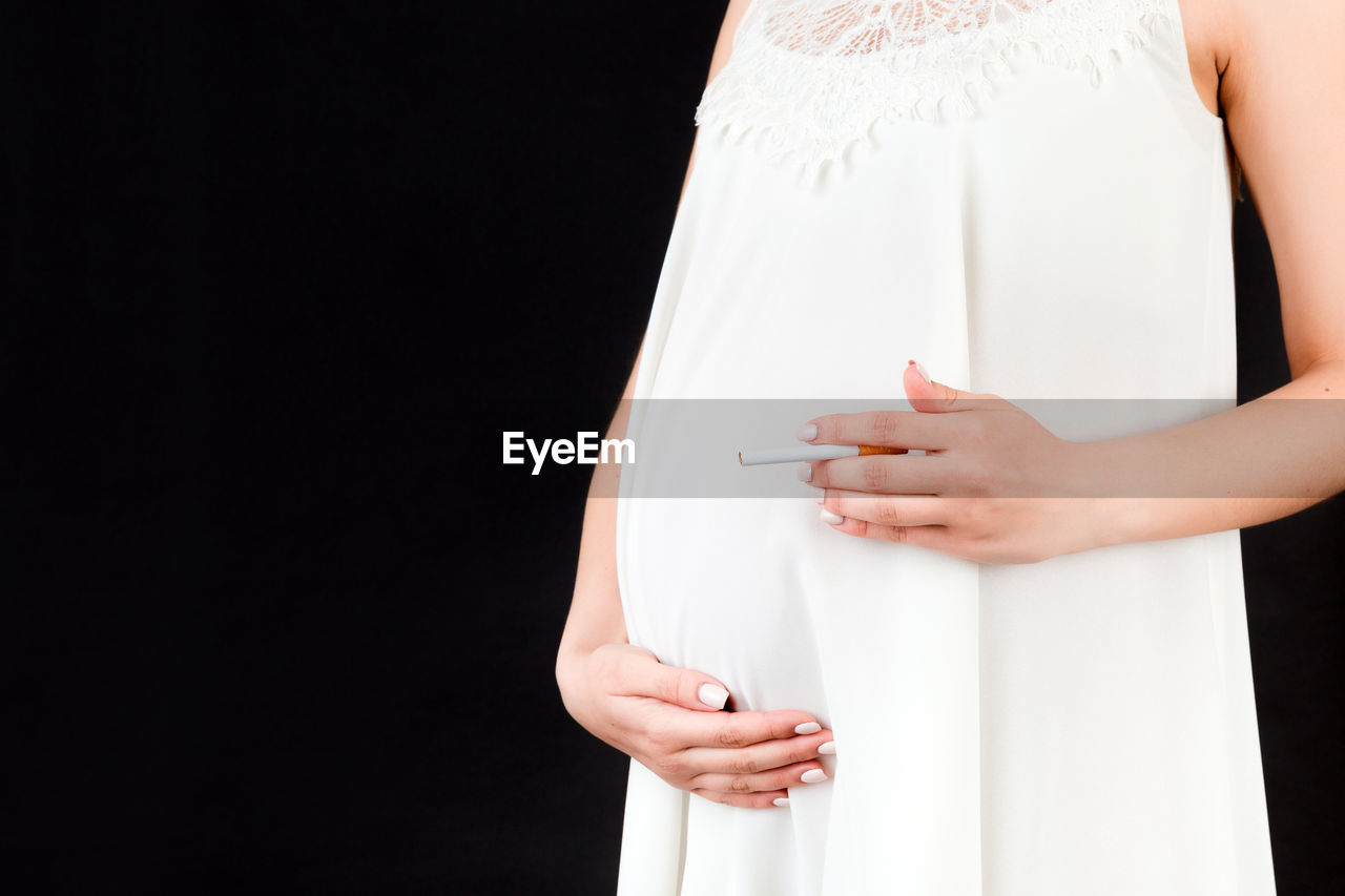 MIDSECTION OF WOMAN HOLDING UMBRELLA