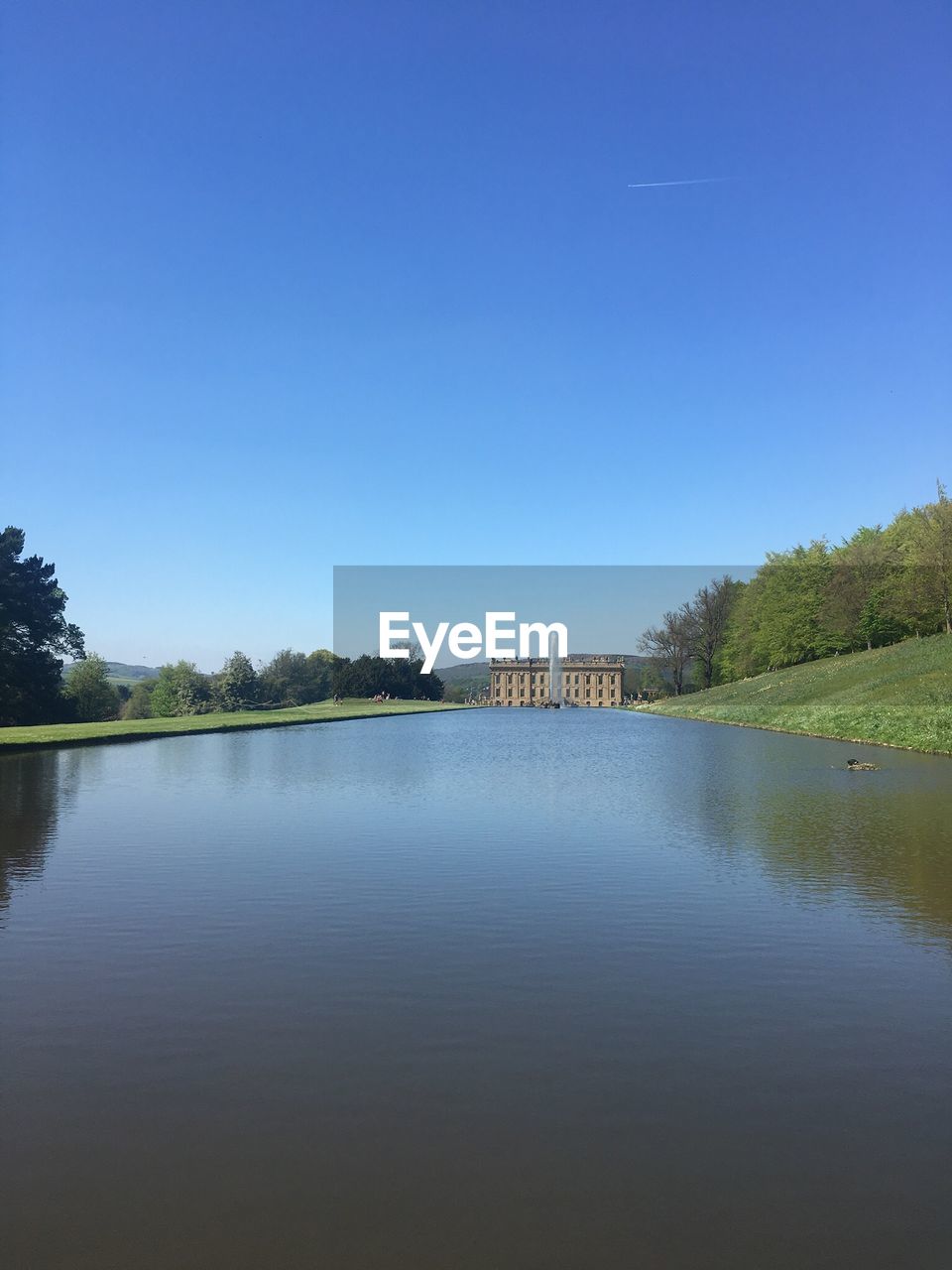 Scenic view of lake against clear blue sky