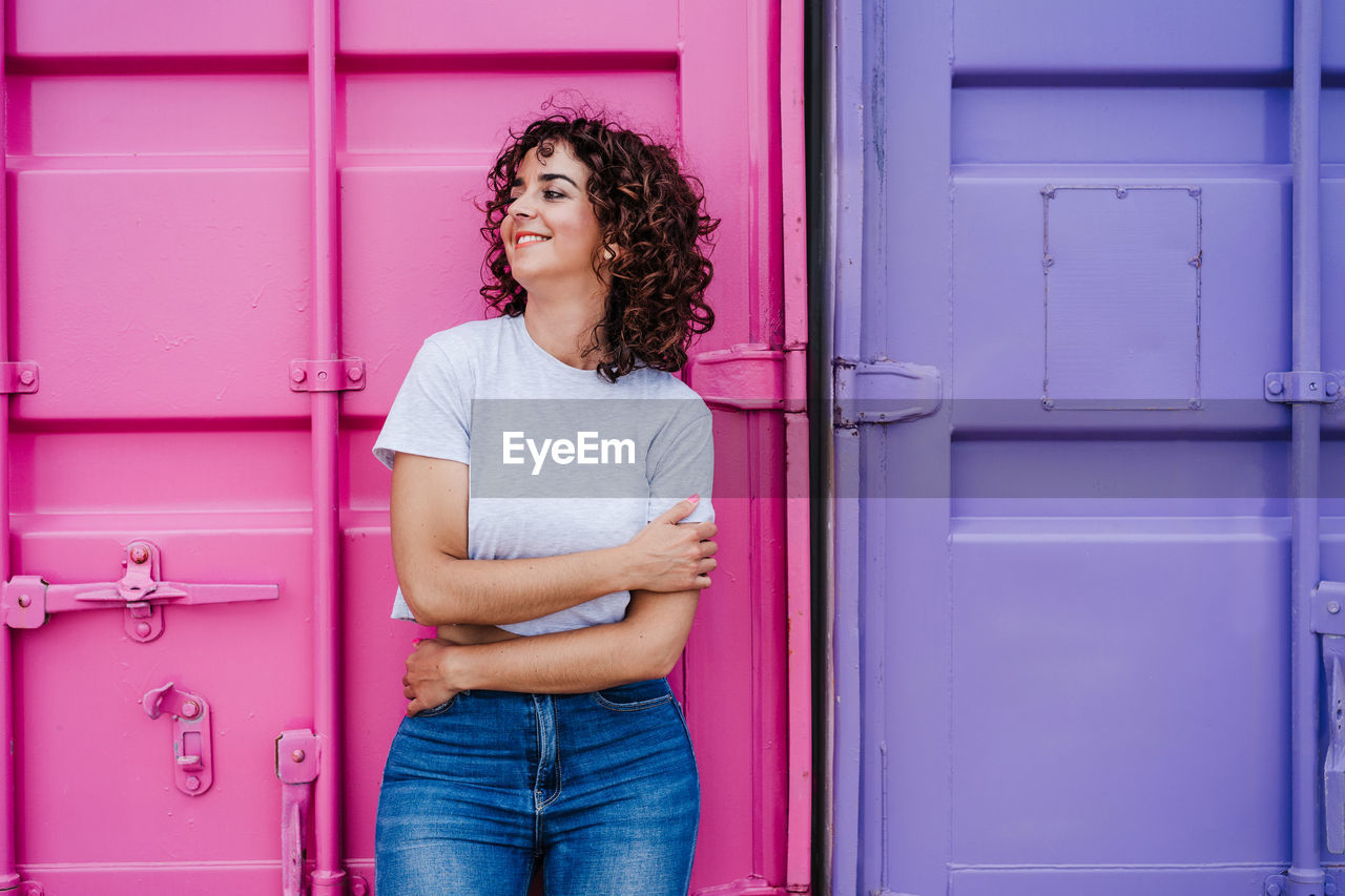 Young woman standing against door of building