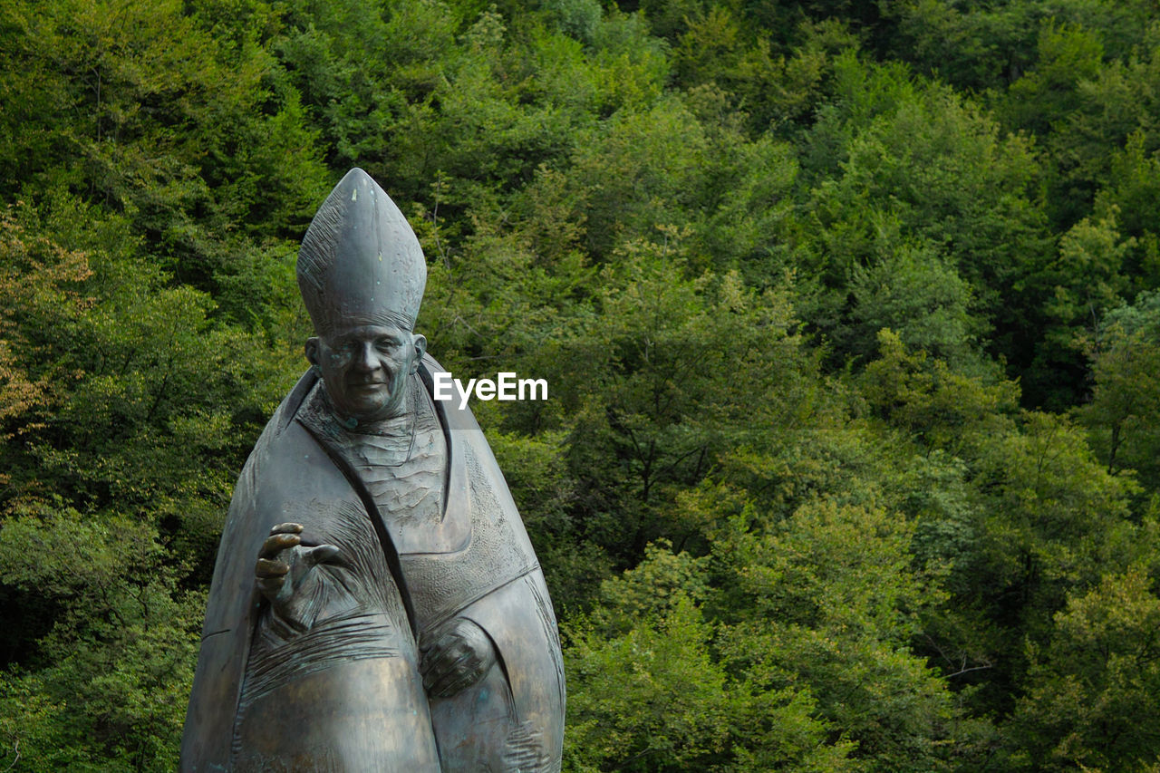 STATUE AGAINST TREES