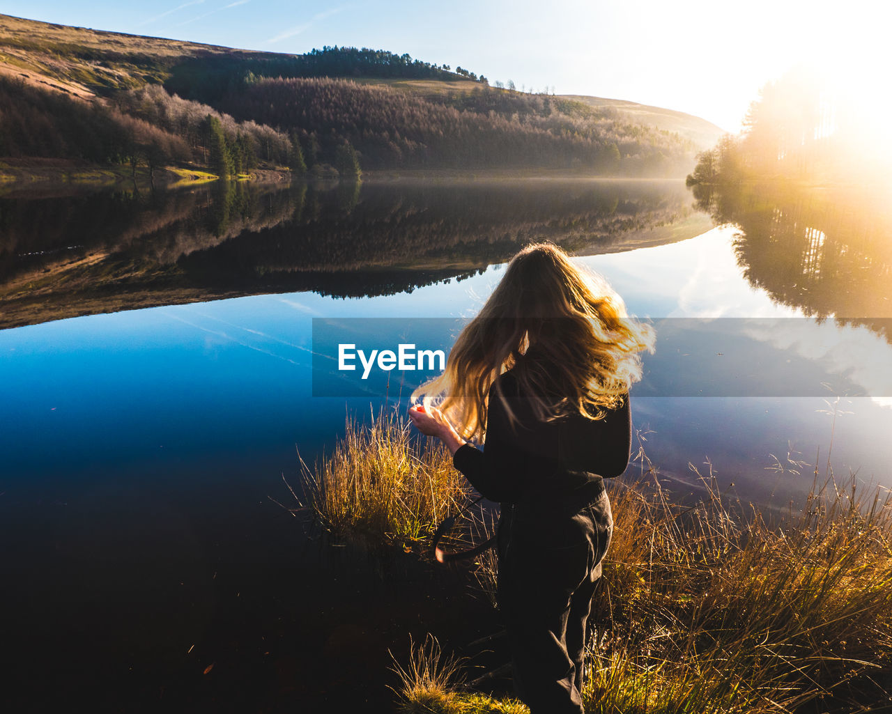 REAR VIEW OF WOMAN STANDING IN LAKE