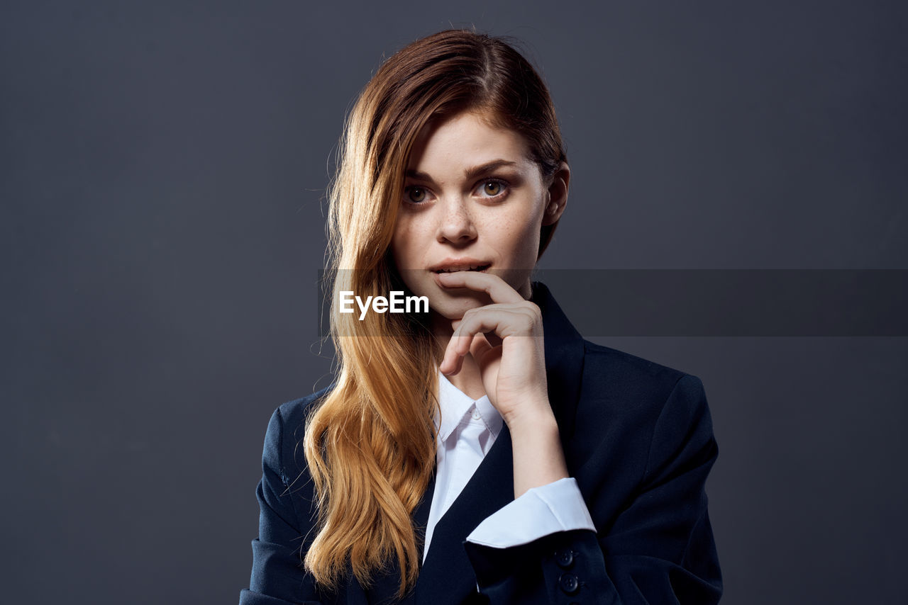 Portrait of beautiful young woman over black background