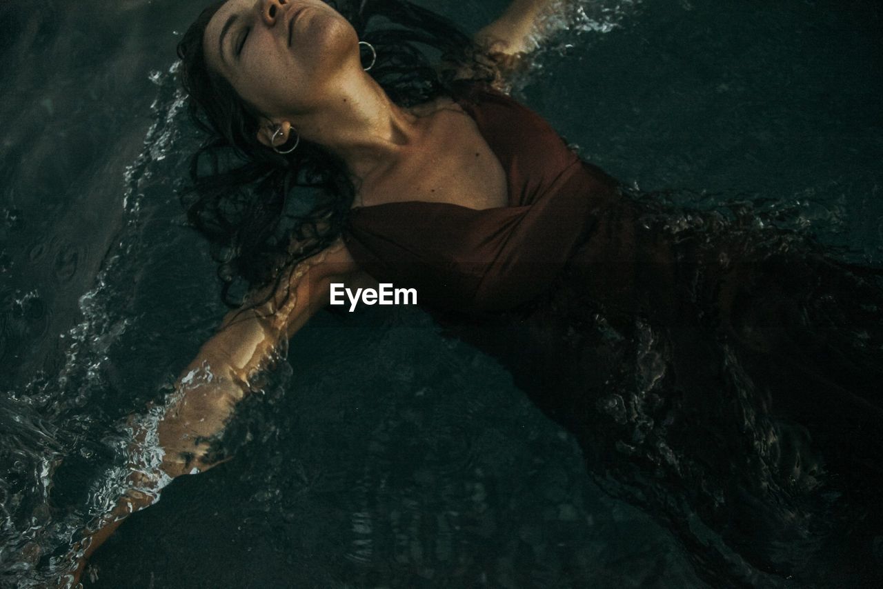 High angle view of woman lying in swimming pool