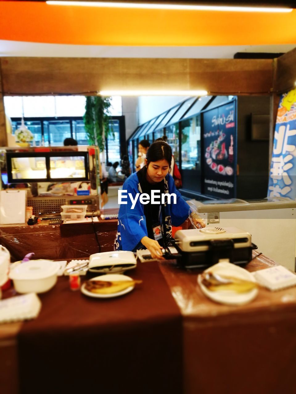 WOMAN SITTING AT RESTAURANT