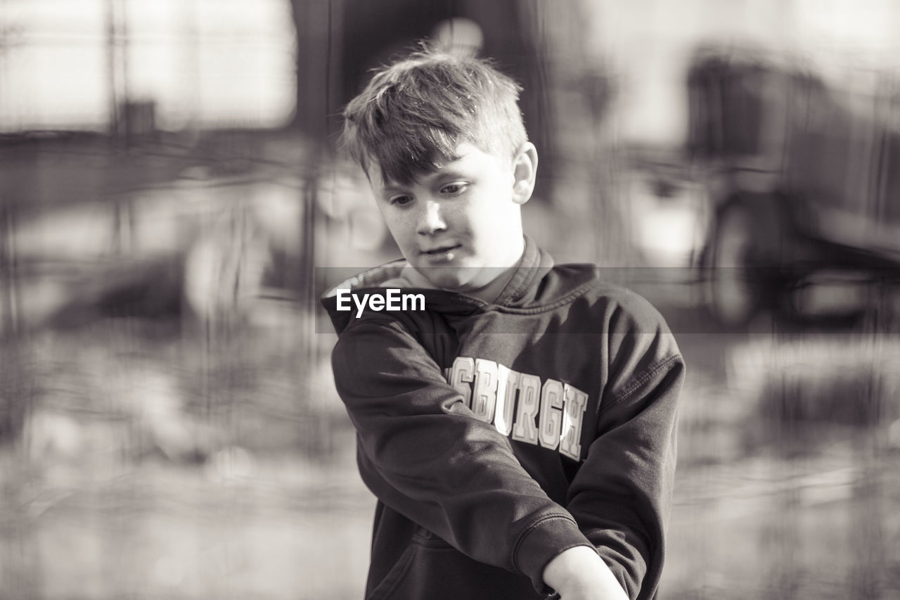 Cute boy looking away while playing outdoors