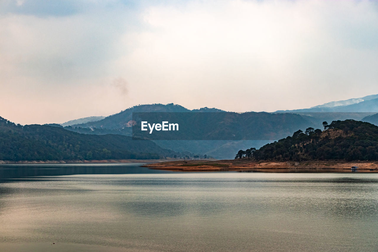 Lake calm water with mountain background at day from flat angle