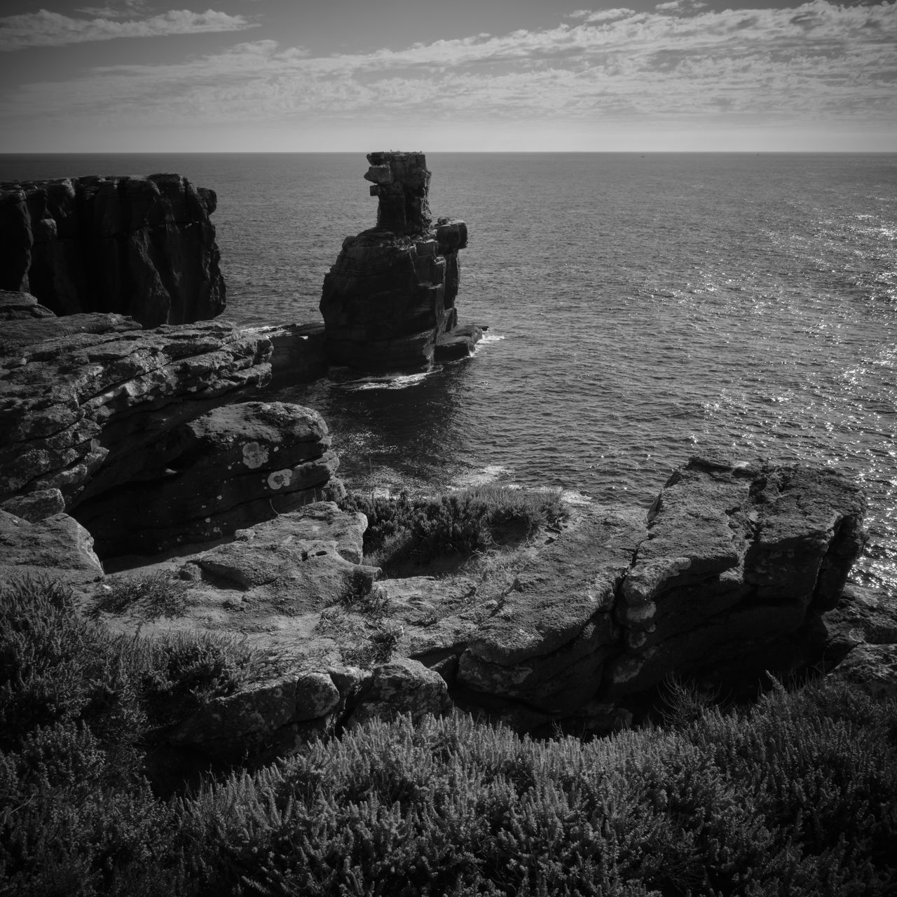 Rocks on sea shore against sky