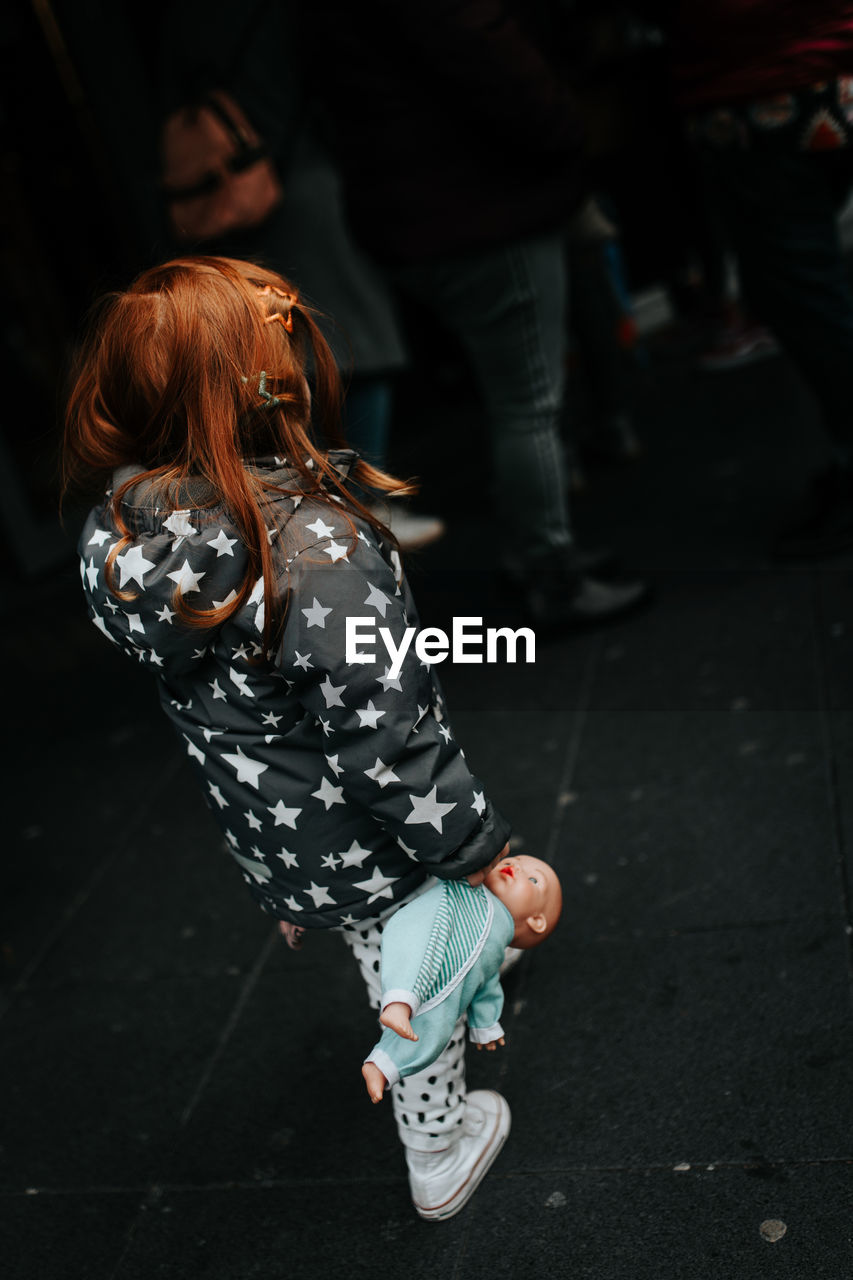 REAR VIEW OF WOMAN ON STREET