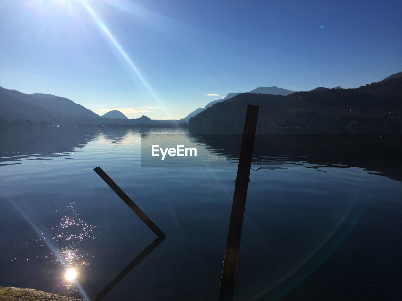 Scenic view of lake by mountains against sky