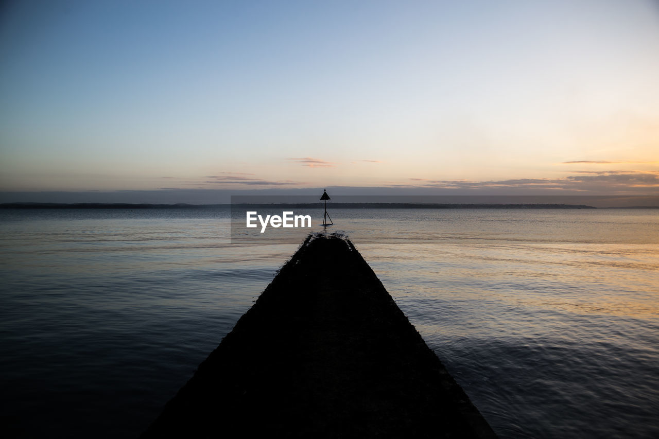 Scenic view of sea against clear sky during sunset