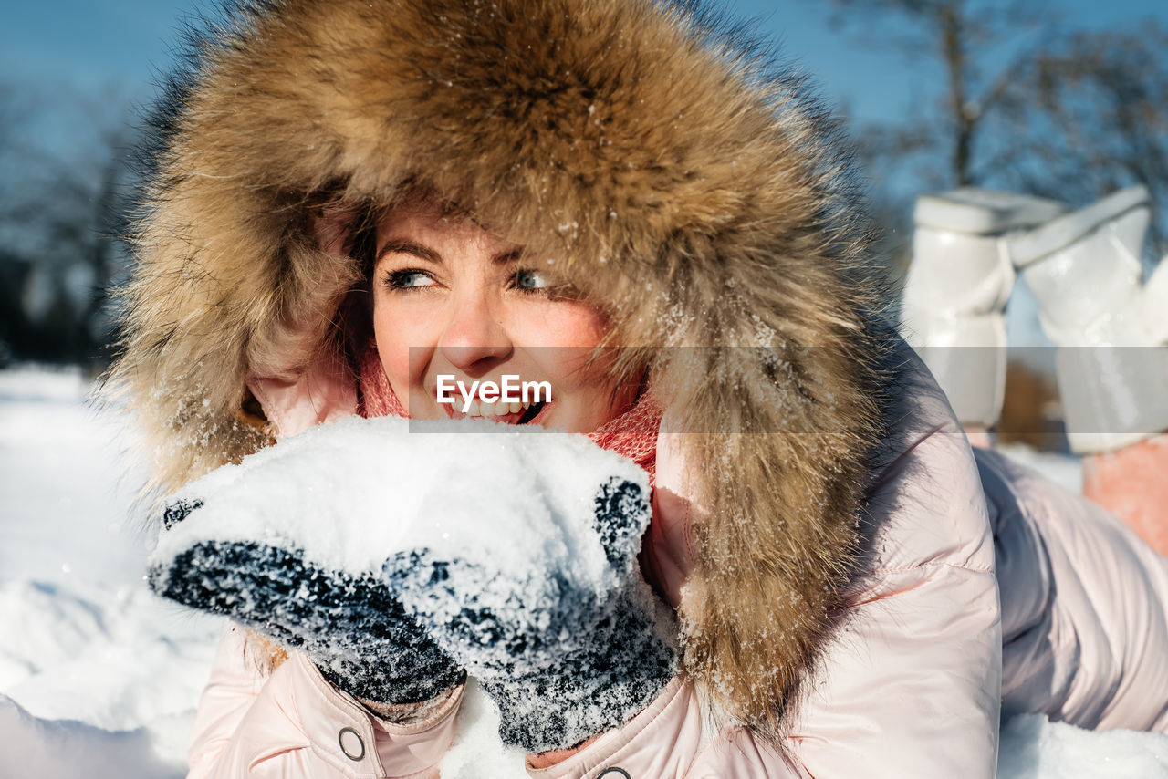 PORTRAIT OF SMILING WOMAN IN SNOW