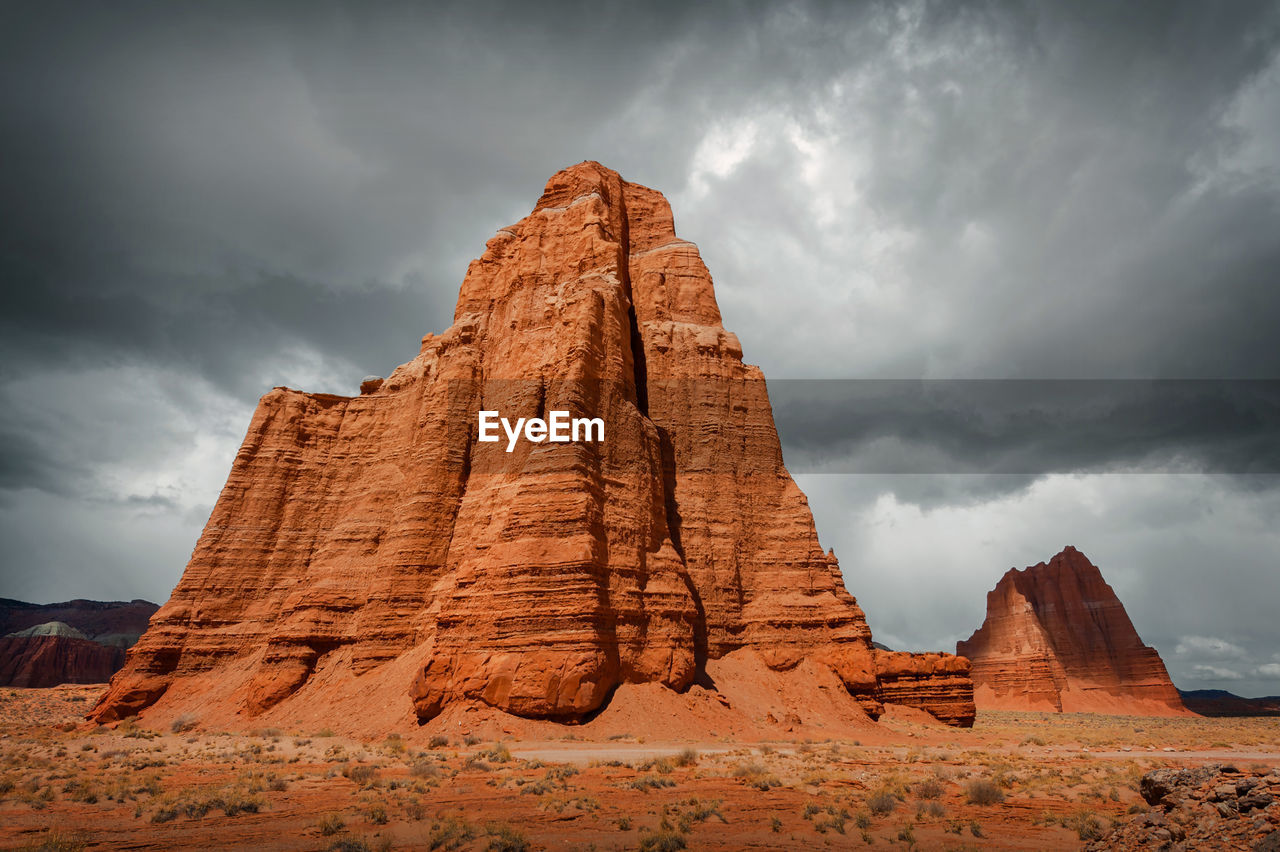 Rock formations on landscape against cloudy sky