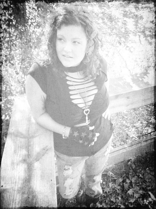 PORTRAIT OF YOUNG WOMAN STANDING ON WALL