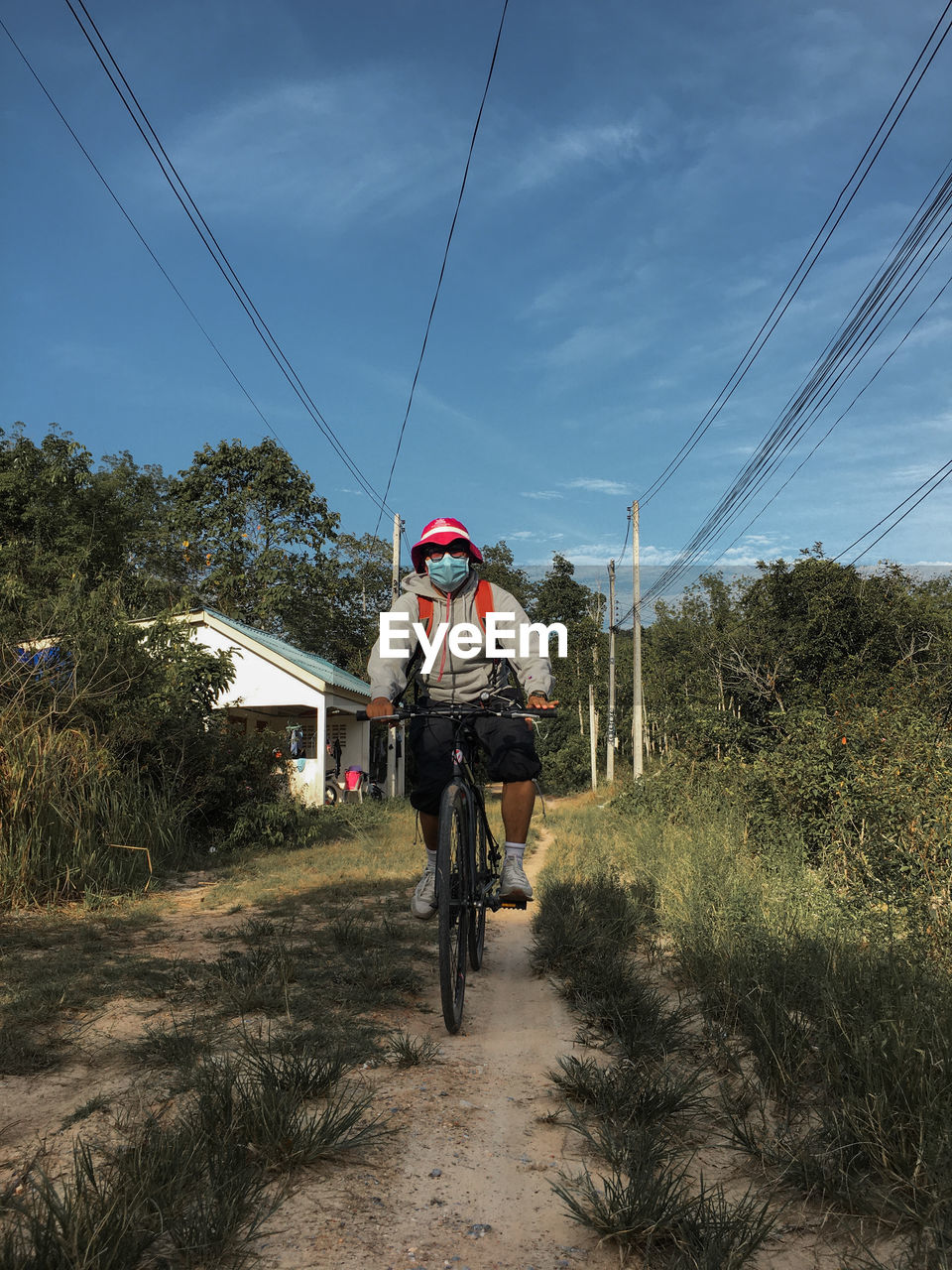 Man riding bicycle on land against sky