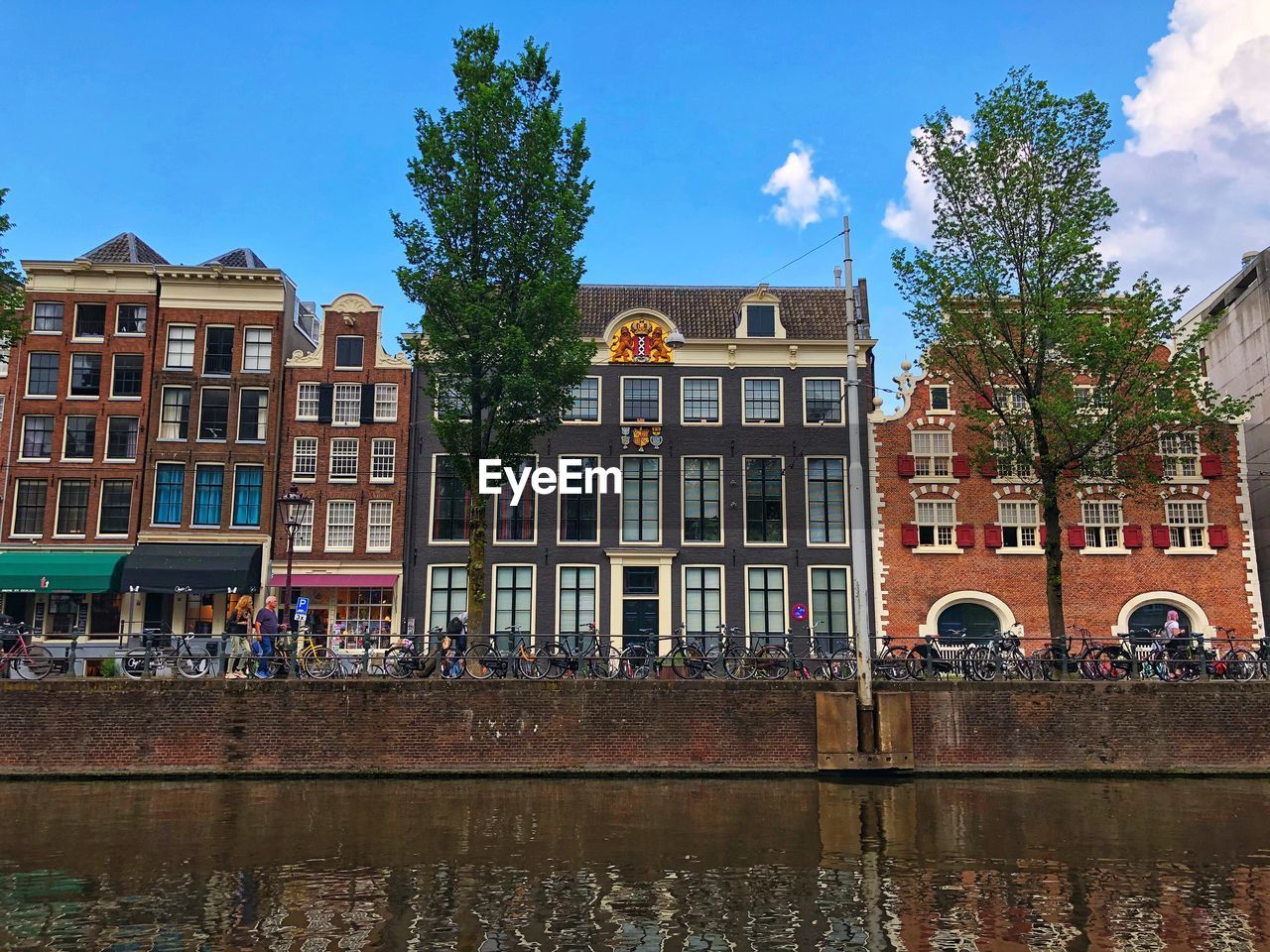 Buildings by lake against sky in city