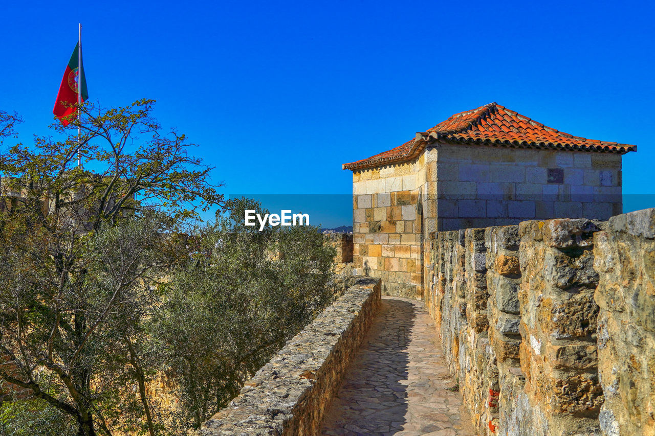 Built structure by building against blue sky. castle, lisbon, portugal 