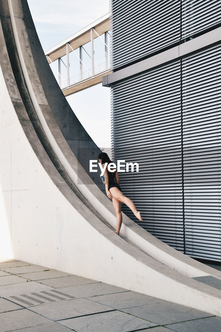 Woman dancing against wall in city