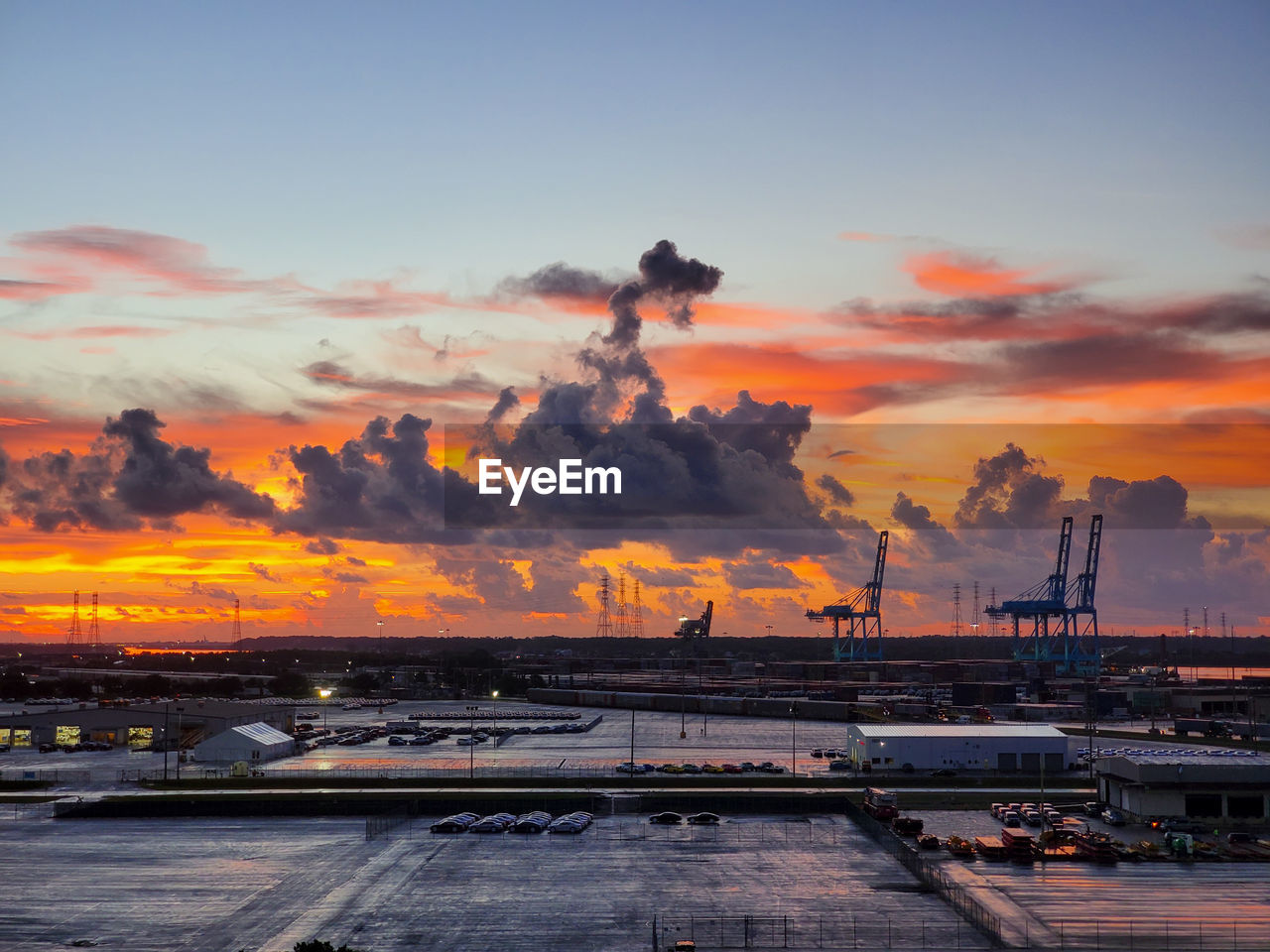 Panoramic view of factory against sky during sunset