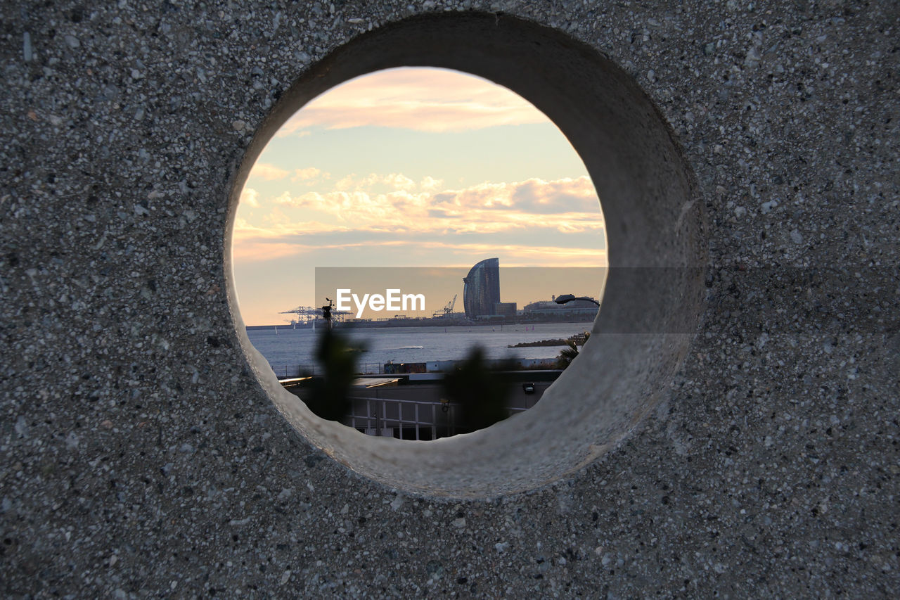 BUILDINGS SEEN THROUGH HOLE IN CITY